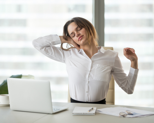Woman stretching at her office desk